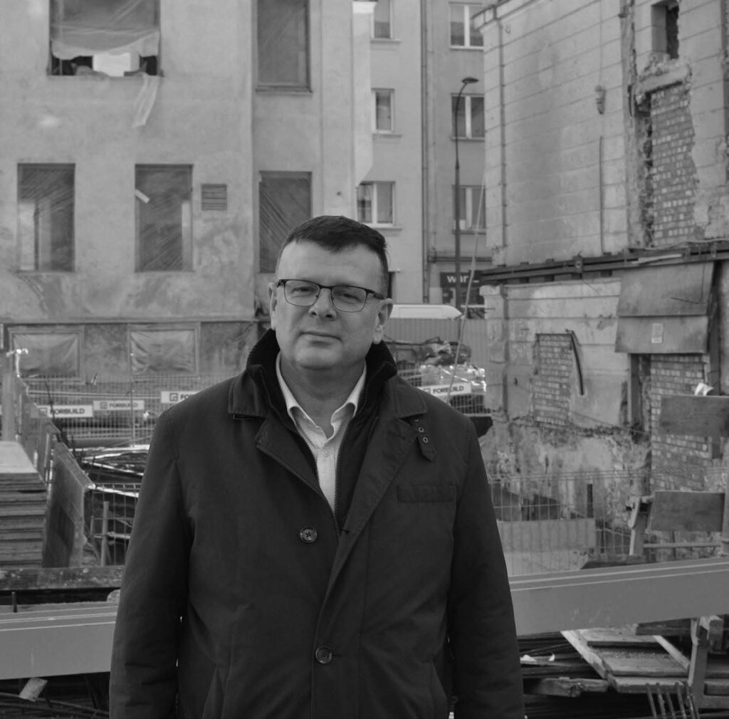 Albert Stankowski na tle powstającej siedziby MGW, przebudowywanego Szpitala Bersohnów i Baumanów