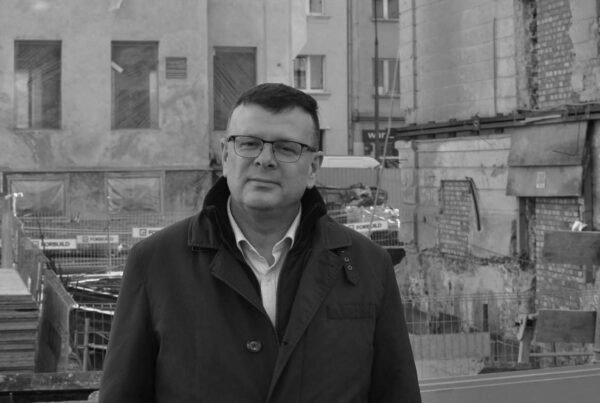 Albert Stankowski na tle powstającej siedziby MGW, przebudowywanego Szpitala Bersohnów i Baumanów